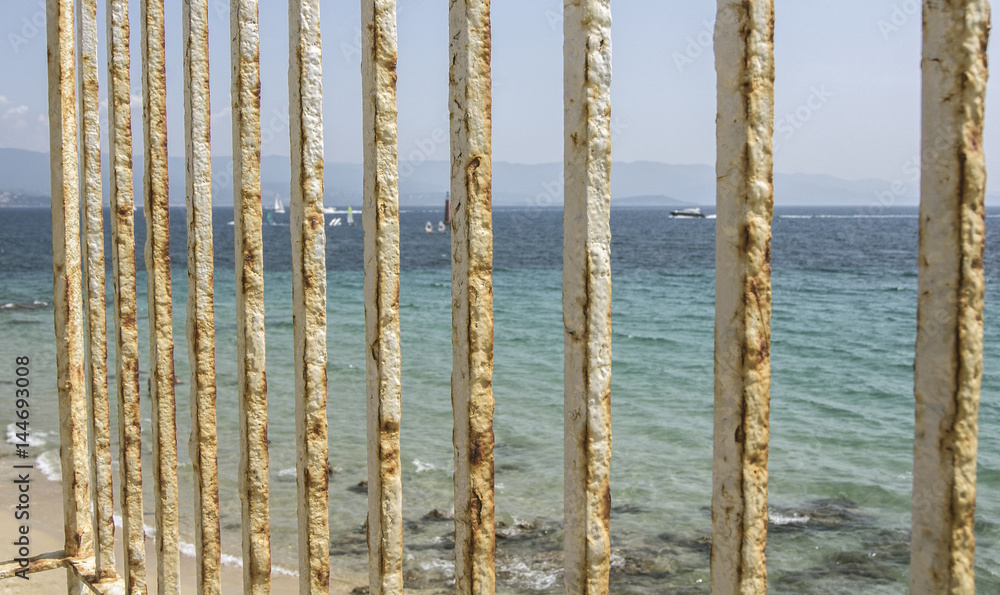 An old rusty white painted fence at the beach