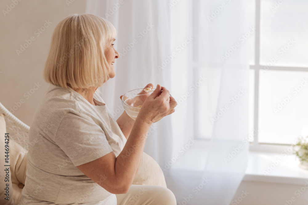 Naklejka premium Pleasant positive woman having breakfast