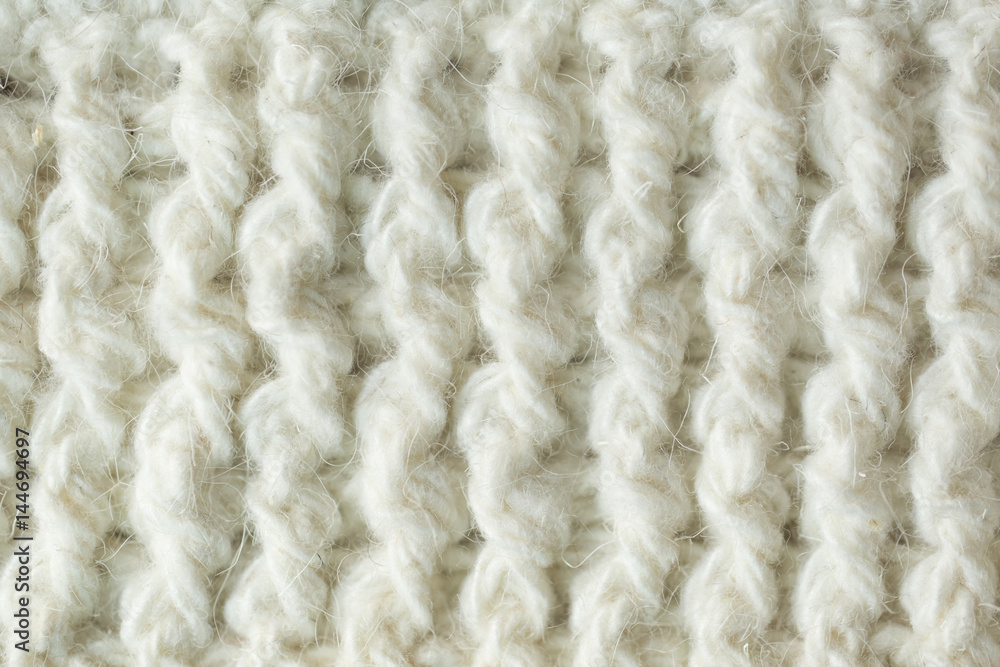 Knit texture of white wool knitted fabric with cable pattern as background Knit texture of white wool knitted fabric with cable pattern as background