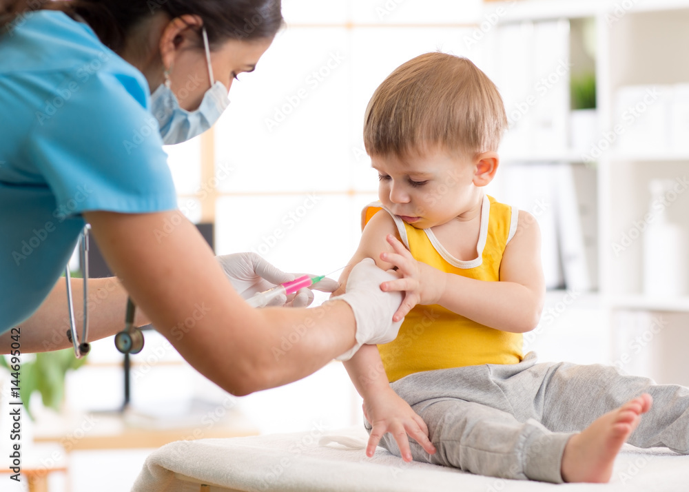 Doctor give injection to boy's arm Doctor give injection to boy's arm