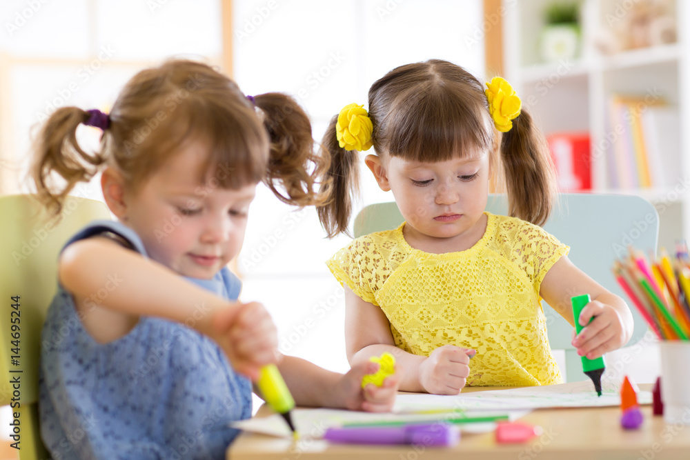 Fototapeta premium Smiling kids drawing together at hobby group indoors