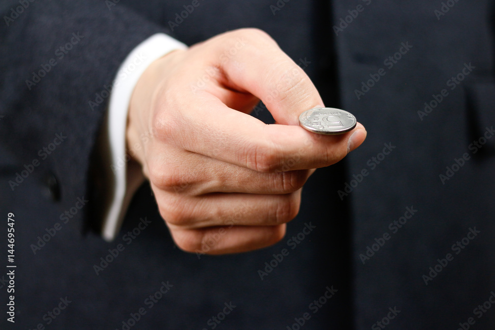 Businessman tossing a coin. Heads or tails. Close up