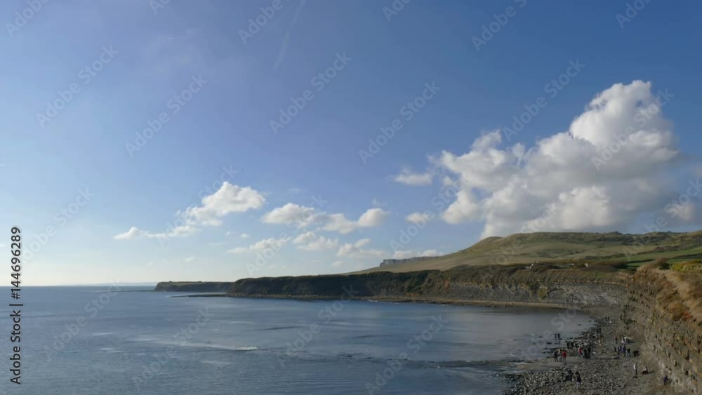 Time lapse of clouds forming and moving over cliffs with the ocean
