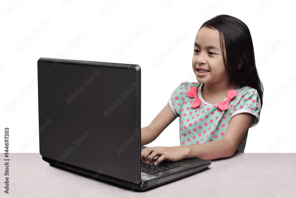 Cheerful asian little girl using laptop on the desk Cheerful asian little girl using laptop on the desk