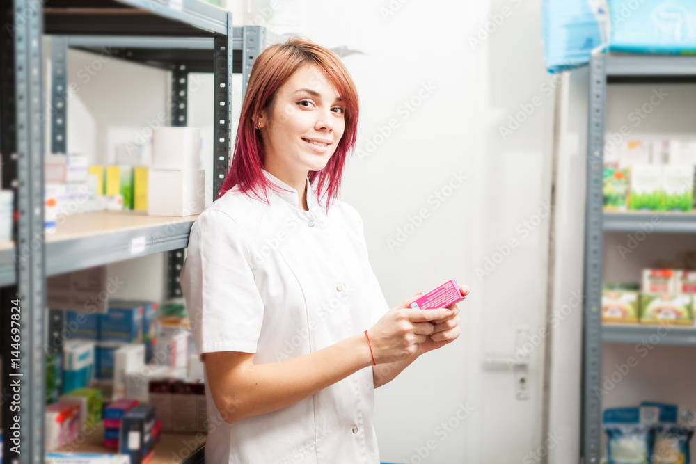 Pharmacist woman in the storage facility next to the shelfs. Healthcare business