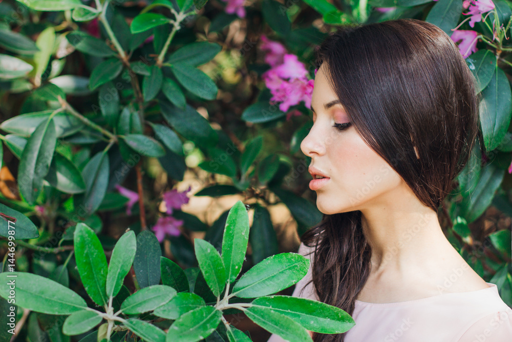 Outdoor fashion photo of beautiful young woman surrounded by flowers. Spring blossom Outdoor fashion photo of beautiful young woman surrounded by flowers. Spring blossom