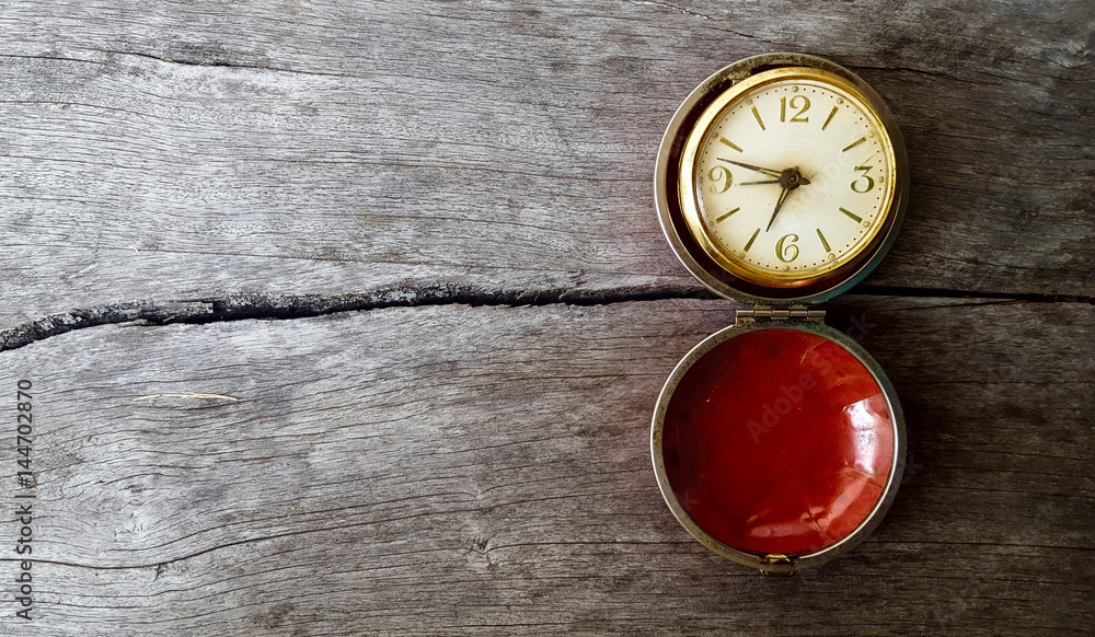 Red pocket watch on wooden background, old pocket watch