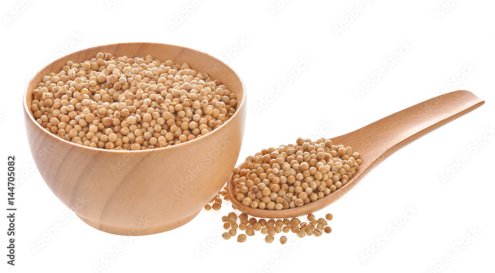 Coriander seeds in a wooden spoon on a white background Coriander seeds in a wooden spoon on a white background