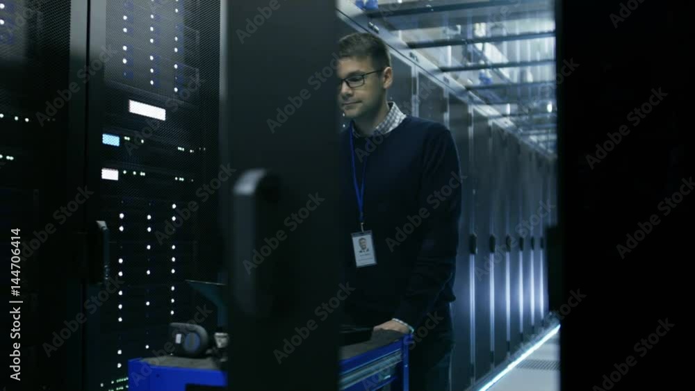 IT Technician in Data Center Pushes Crash Cart Through Sliding Doors ...