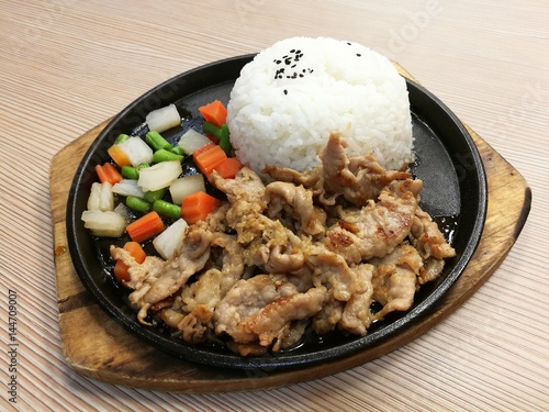 Grill pork slice on hot BBQ pan with vegetable serve with rice, stir fried pork with garlice, lunch set meal, ready to eat, quick meal,Thai food, focus-on-foreground with blur background, top view photo