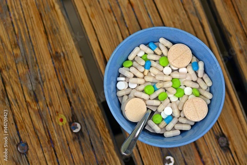 Bowl full of tablets on a wooden table