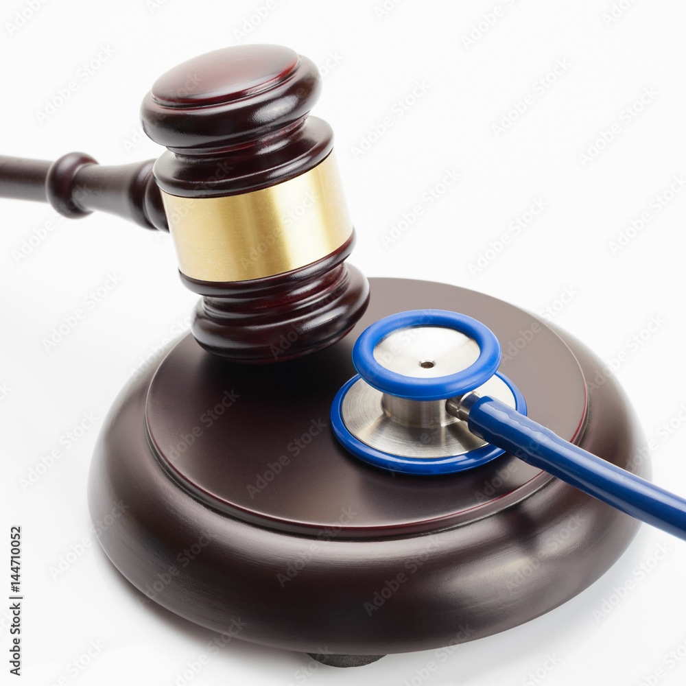 Close up shot of a wooden judge gavel and a stethoscope Close up shot of a wooden judge gavel and a stethoscope