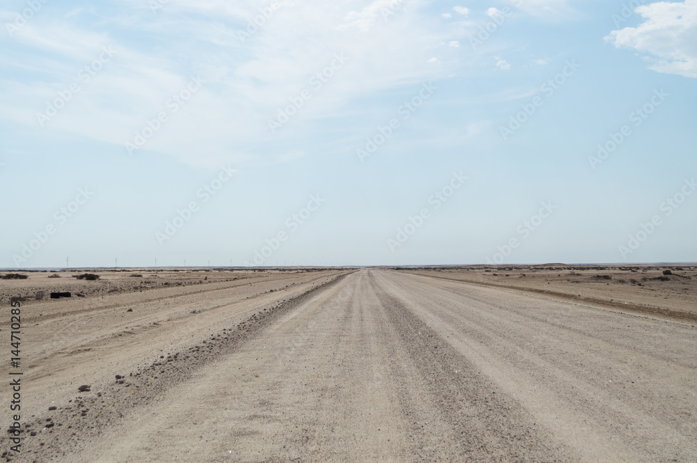 Naklejka premium Endless Dirt Road in the Desert between Walvis Bay and Solitaire in Namibia