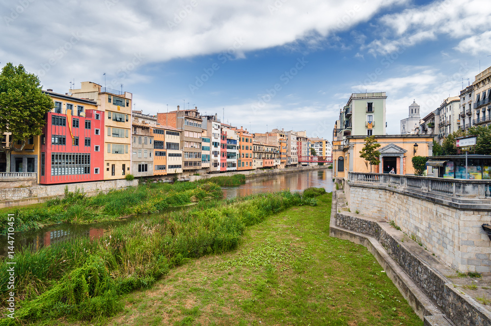Fototapeta premium Cloudy view of riverside and bridge over river Onyar, Girona, Catalonia, Spain.