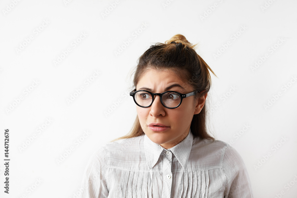 Close up portrait of confusion office worker female in eyeglasses shocked with unbelievable news about the accident, happened at work, looking aside with opened mouth and frightened eyes. Close up portrait of confusion office worker female in eyeglasses shocked with unbelievable news about the accident, happened at work, looking aside with opened mouth and frightened eyes.