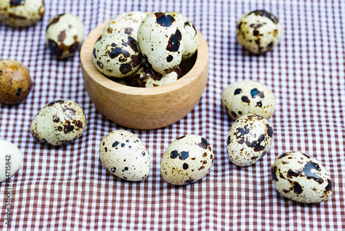 Quail eggs - Quail eggs in a wooden bowl on old brown wooden surface background, selective focus.