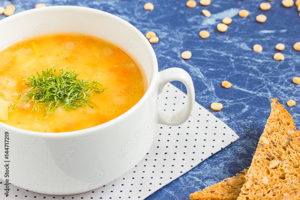 Pea soup with chopped dill in a white bowl on a marble table Pea soup with chopped dill in a white bowl on a marble table