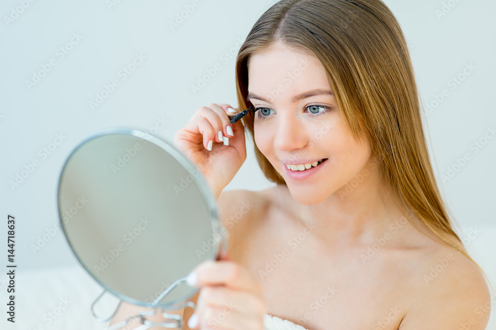 Woman curling eyelashes