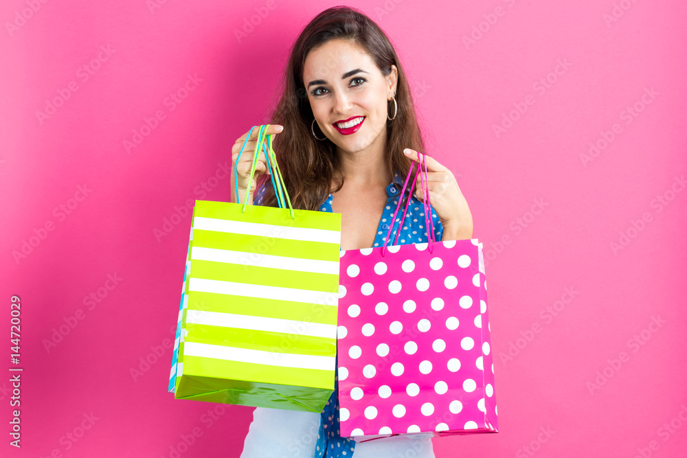 Fototapeta premium Happy young woman holding many shopping bags