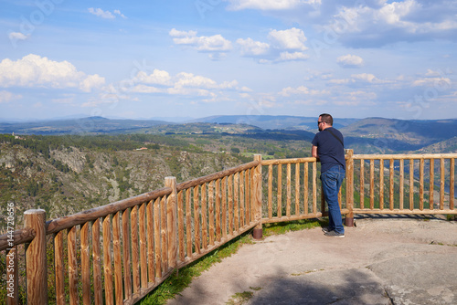 Hombre joven admirando el paisaje desde el mirador de Los Balcones de Madrid en Ourense