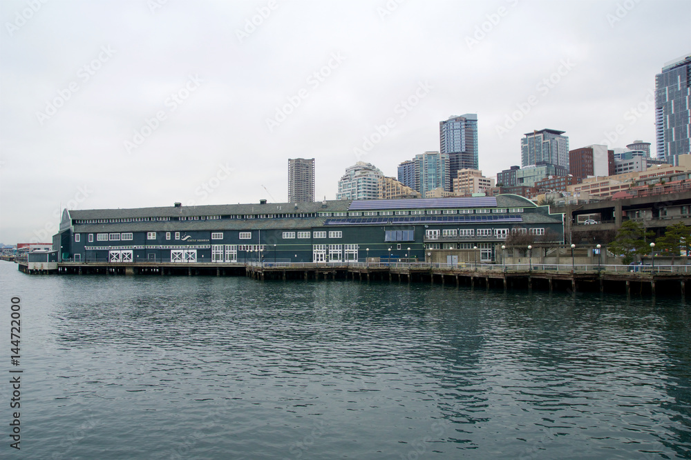 SEATTLE, WASHINGTON, USA - JAN 25th, 2017: A view on Seattle downtown from the waters of Puget Sound. Piers, skyscrapers, Seattle Aquarium in the city before sunset