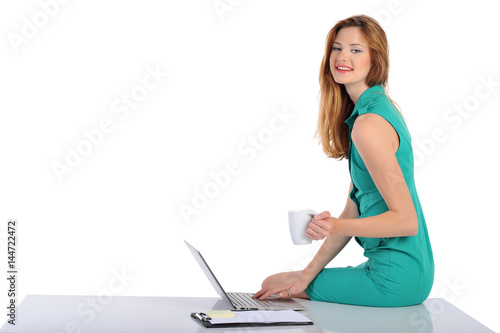young blonde business woman working on laptop computer, isolated on white background.