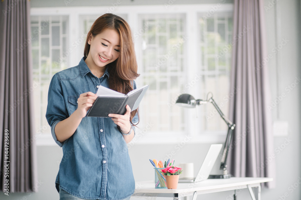 indoor picture of smiling Asia woman with notebook and pen indoor picture of smiling Asia woman with notebook and pen