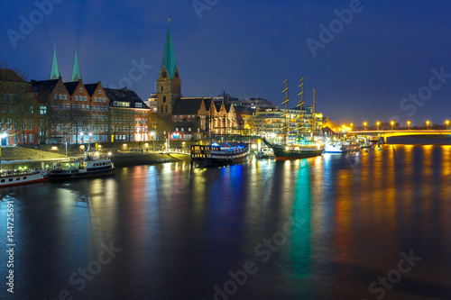 Embankment of the Weser River and Protestant Lutheran Saint Martin Church in the old town of Bremen  Germany. Night panoramic view.