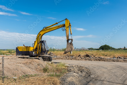 construction site with dirty yellow excavator during work