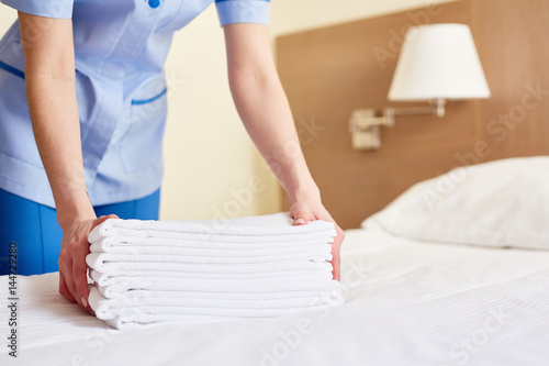 Chambermaid holding clean white towels