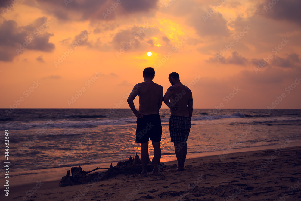 People build a castle of sand on the ocean.