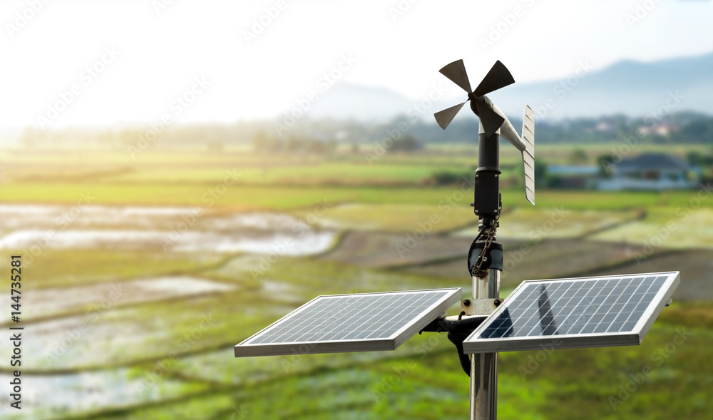 Smart agriculture and smart farm technology concept. Revolving vane anemometer, a meteorological instrument used to measure the wind speed and solar cell system with rice field background. - obrazy, fototapety, plakaty 