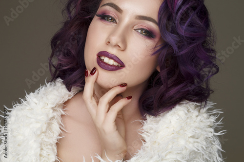 Portrait of young beautiful woman with violet make up and purple hair. Beauty concept.