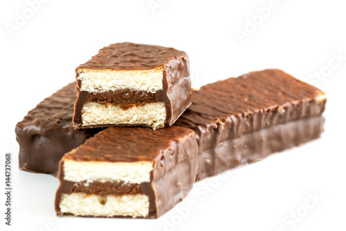 mini sponge cakes with cocoa cream and chocolate coating over white