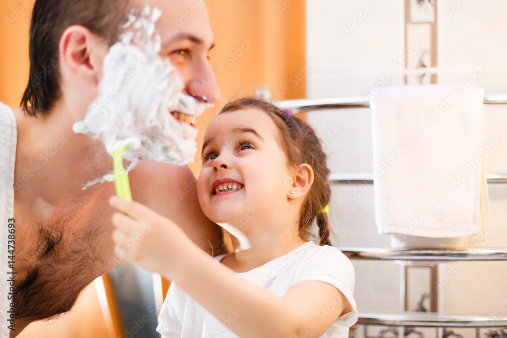 happy father and daughter having fun with shaving foam in the bathroom happy father and daughter having fun with shaving foam in the bathroom