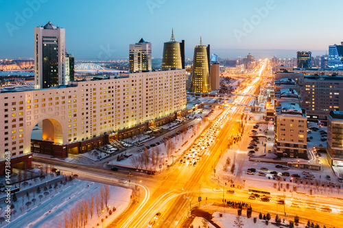 View from above on a large avenue that goes to the horizon, a golden skyscraper and a house of ministries in Astana, Kazakhstan photo