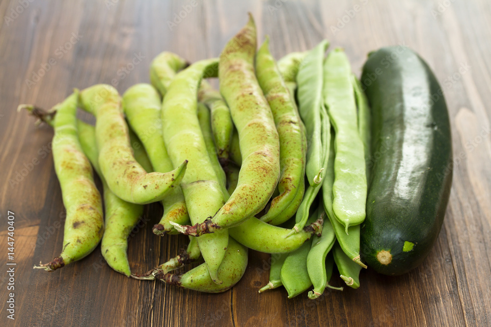 green fresh vegetables on brown wooden background green fresh vegetables on brown wooden background
