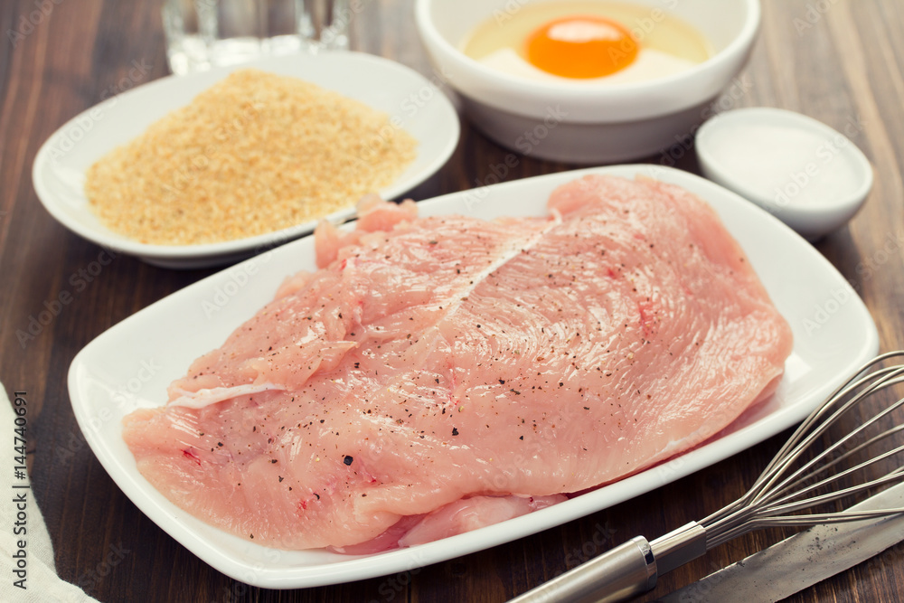 raw turkey, dry bread and egg on wooden background