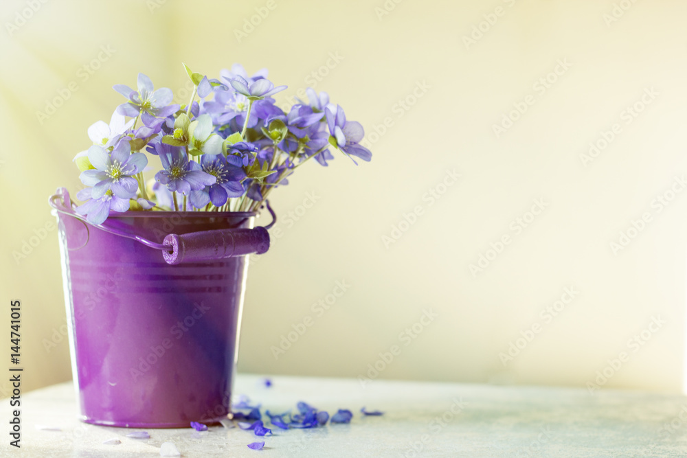 Bucket of flowers on the table with blurred background on a sunny day