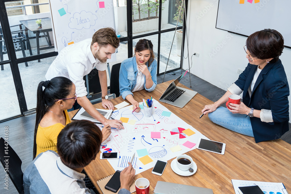 Obraz premium Group Of Asian and Multiethnic Business people with casual suit working and brainstorming together in the modern Office, Top view, people business group concept