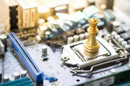 Gold chess piece on computer mainboard. Concept of IT strategy, making decision, technology background.