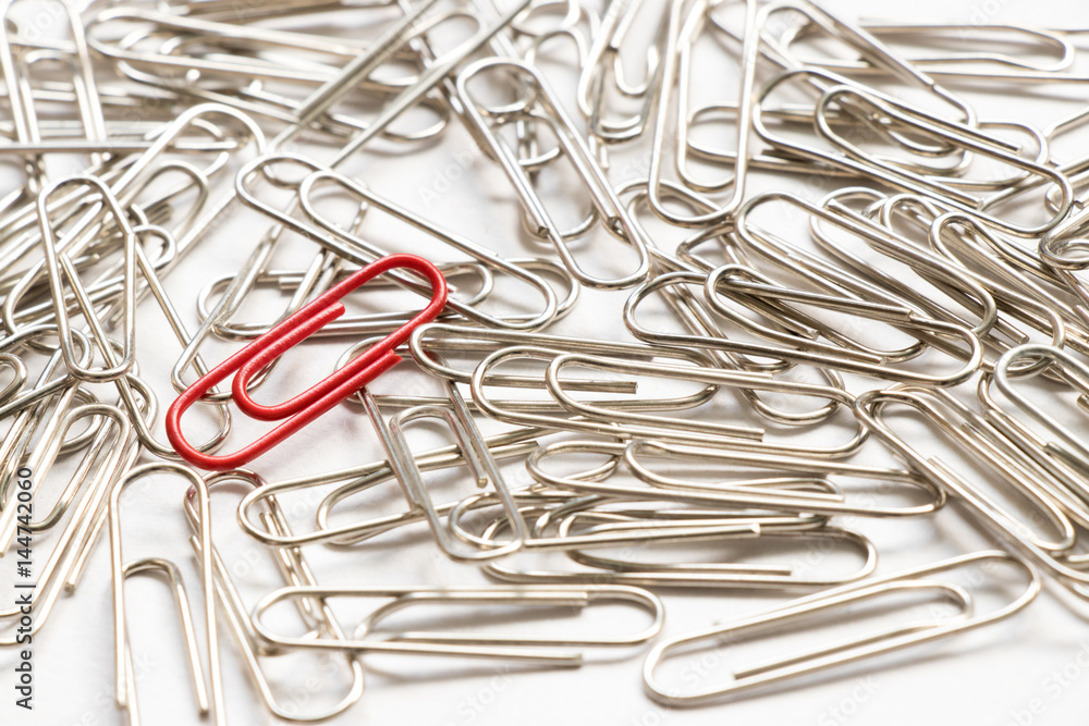 Red paper clip show different from the others on white background Red paper clip show different from the others on white background