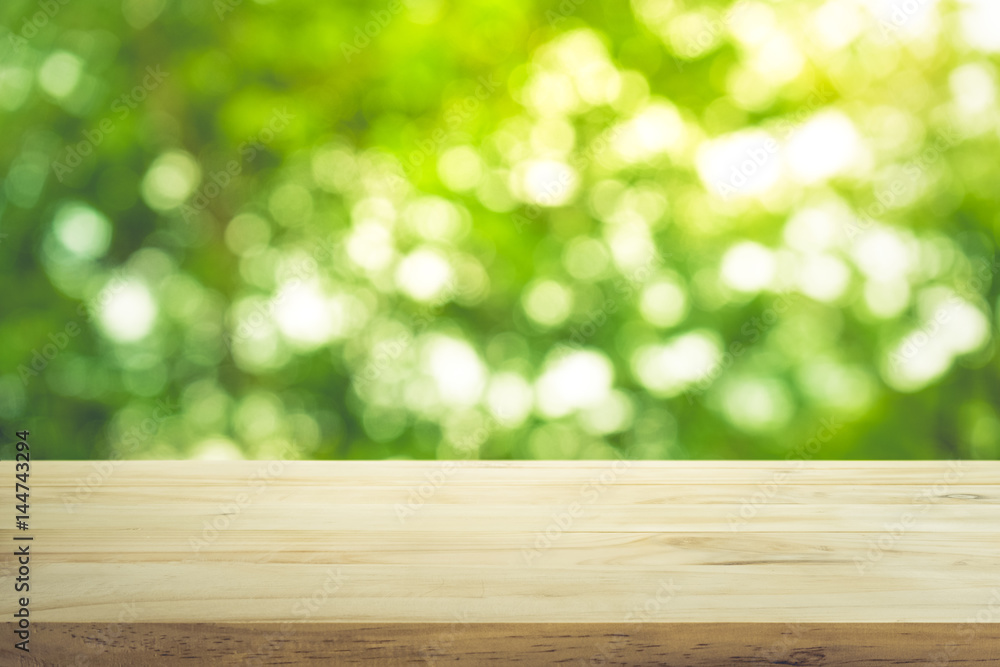 Empty of wood table top on blur of fresh green abstract from garden with sunlight .For montage product display or key visual layout Empty of wood table top on blur of fresh green abstract from garden with sunlight .For montage product display or key visual layout