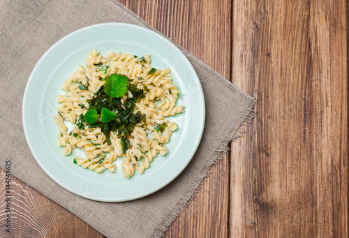 Pasta with pesto sauce, on a wooden background. Italian food.