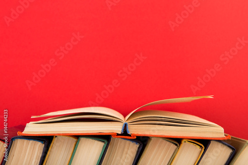 education and wisdom concept - open book on wooden table, color background
