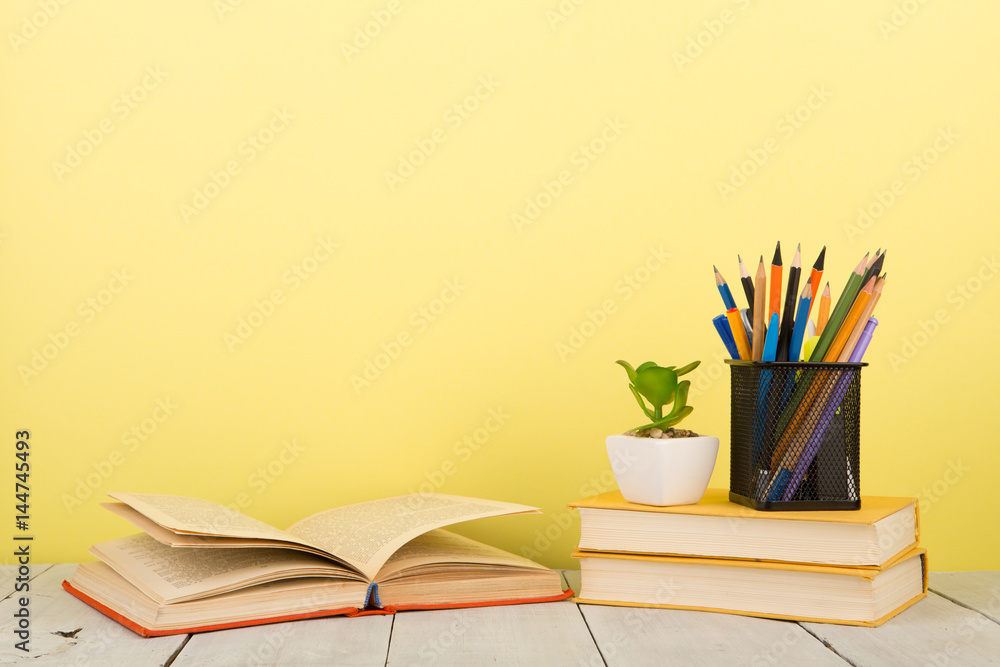 education and wisdom concept - open book on wooden table, color background