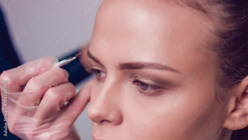 Professional make-up artist drawing eyebrows of model. Beauty, makeup and fashion concept. Close up. Professional make-up artist drawing eyebrows of model. Beauty, makeup and fashion concept. Close up.