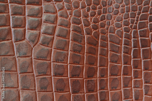 Genuine leather texture backgroundr close-up, embossed under the skin a reptile, brown color print. Natural backdrop, copy space. Concept of shopping, manufacturing photo