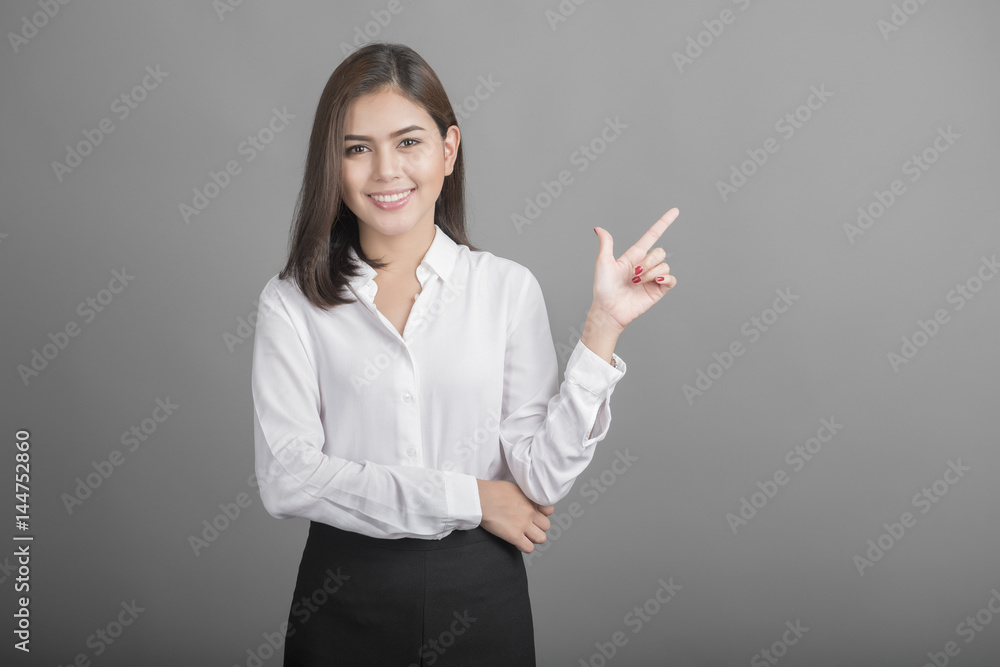 Beautiful Business Woman presenting something on grey background Beautiful Business Woman presenting something on grey background