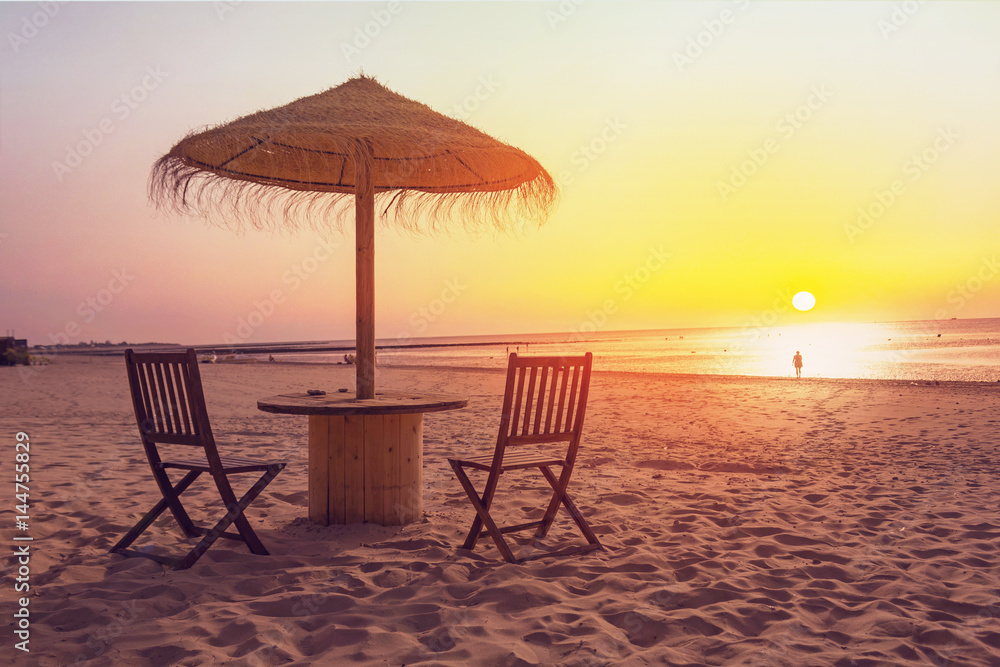 Wooden table and chairs with umbrella on the beach Wooden table and chairs with umbrella on the beach